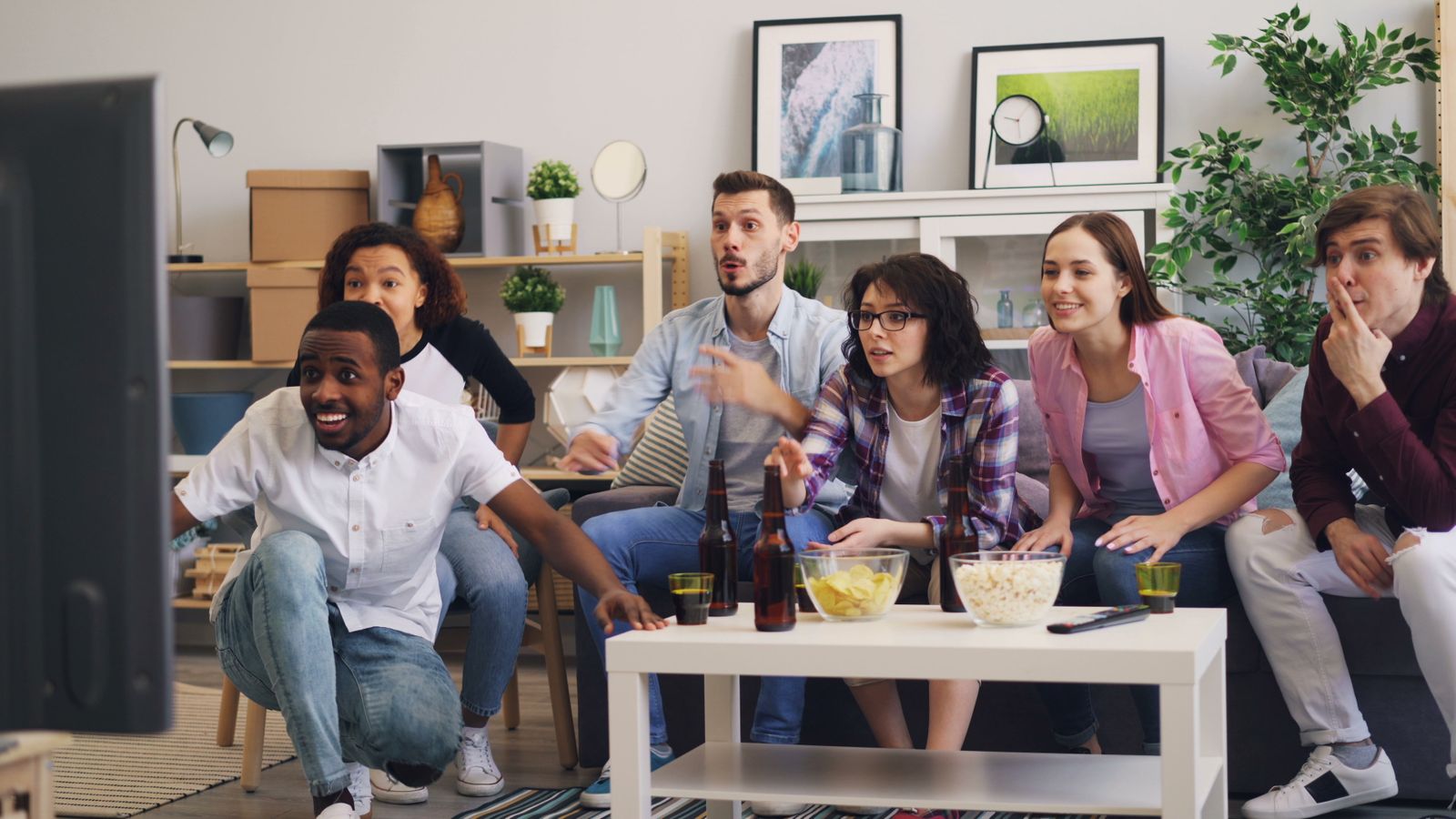 Un grupo de amigos comparte un momento ante la televisión.